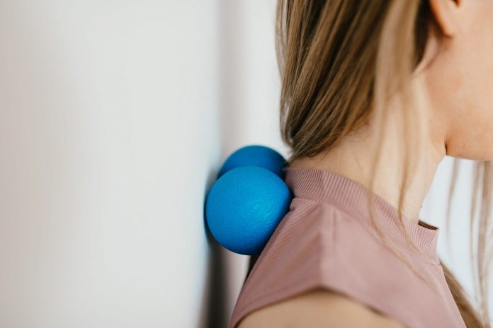 lady releasing neck pain using a dumbbell