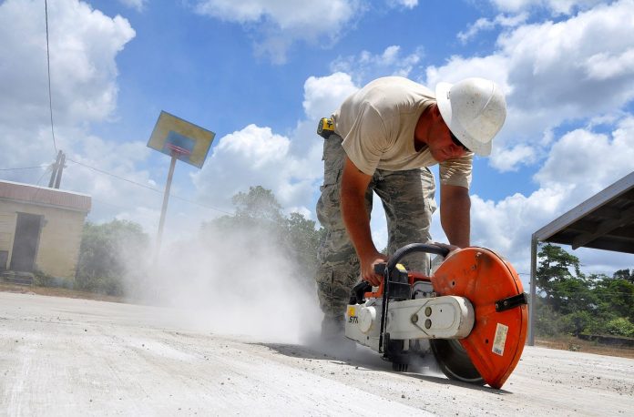 worker cutting sheet using electric saw