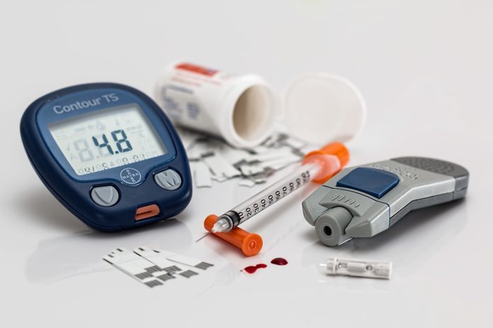 Home glucometer with strips and lance, with some drops of blood