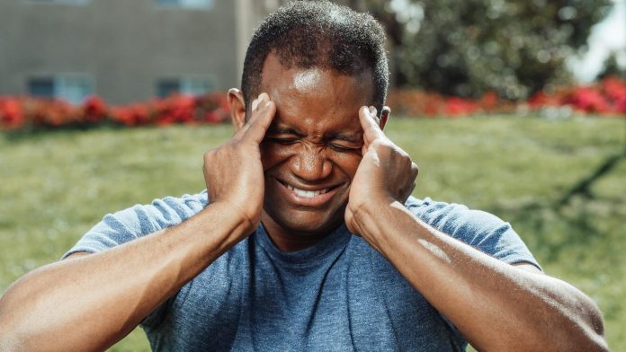 person holding head with pain