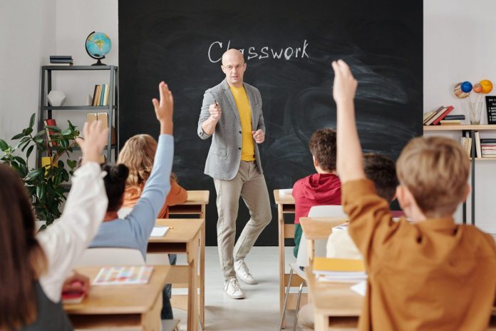 students raising hand in classroom