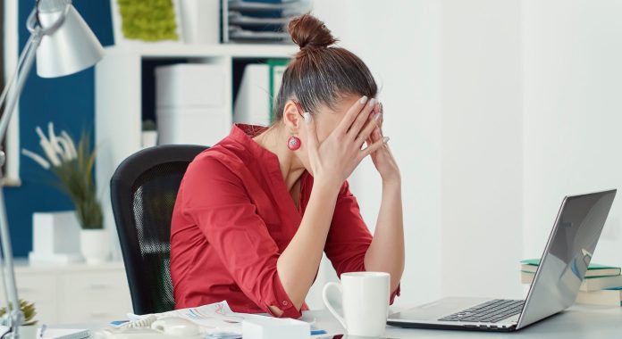 depressed woman sitting on her office desk