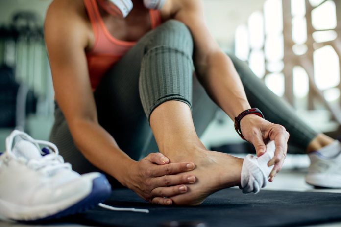 woman in sportsclothing stretching calf