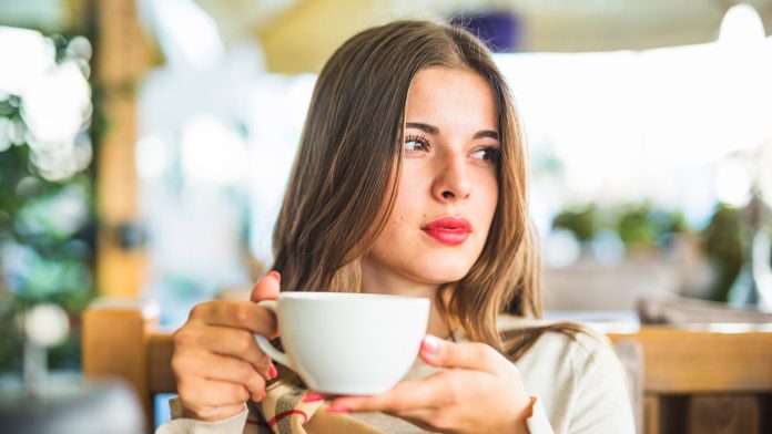 beautiful young woman holding coffee cup