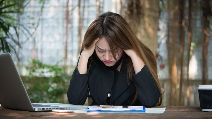 Stressed busineswoman holding her head on the desk