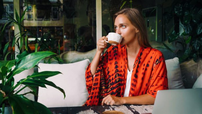 a young lady drinking coffee in a hotel