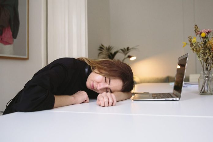 sleeping young lady on desk with open laptop