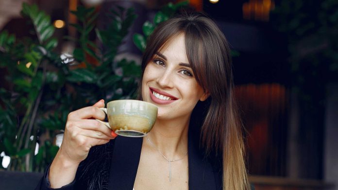 businesswoman drinking coffee sitting at a table