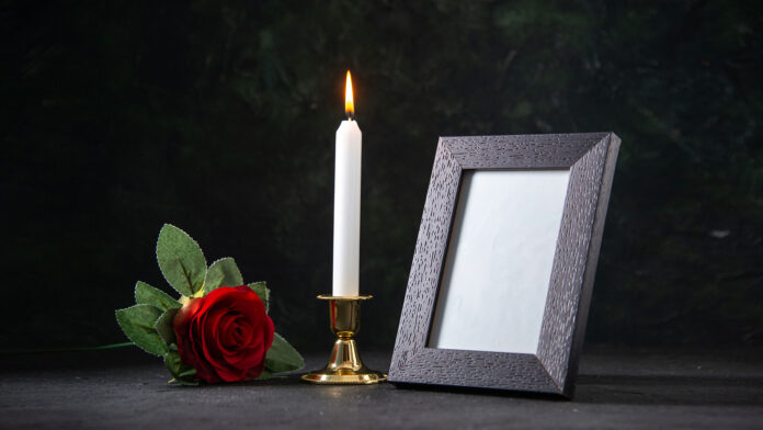 front-view-burning-candle-with-picture-frame-dark-surface